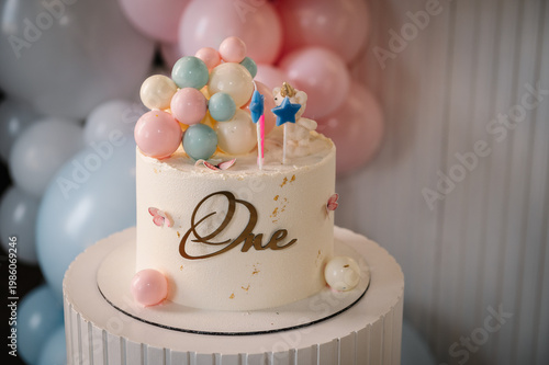 Elegant white 1st birthday cake on a fluted pedestal with 