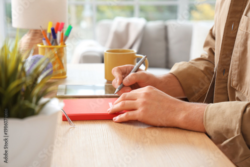 Young man with tablet, cup ...