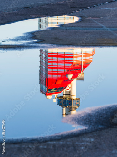 Reflection of famous skyscraper in Gothenburg Sweden seen in a puddle on a clear morning