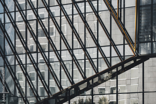 Geometry pattern within modern grid of glass windows and exposed structure on architecture building facade suggesting industrial order and design
