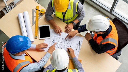 Construction Engineers and Architects Discussing Building Blueprint at Office Table