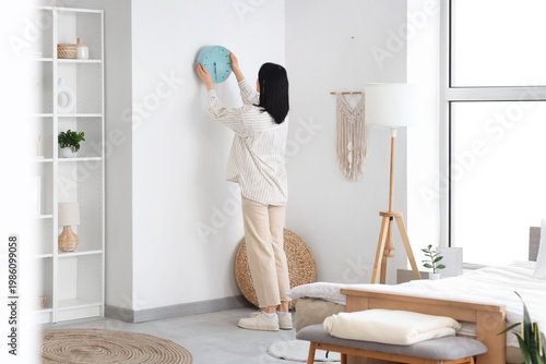 Young woman hanging blue cl...