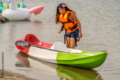 Fotografia Young woman enjoying kayaking at lagoon during summer vacation