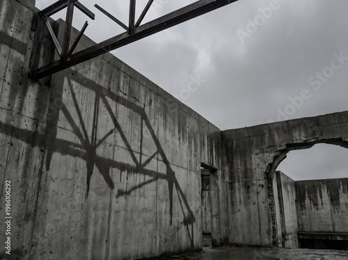 Abandoned Construction Site Interior with Concrete Walls and Steel Beams Under Cloudy Sky
