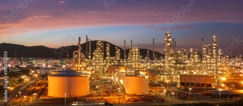 Aerial view of oil refinery and storage tanks at dusk and night, showcasing energy industry infrastructure, petroleum processing, and industrial landscape.
