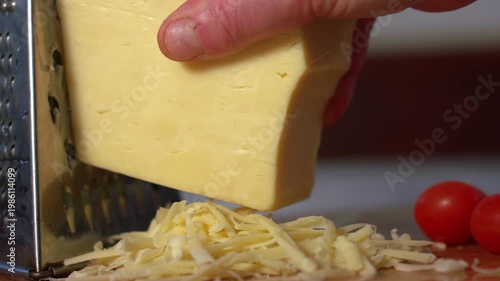 Grating cheese onto a wooden chopping board