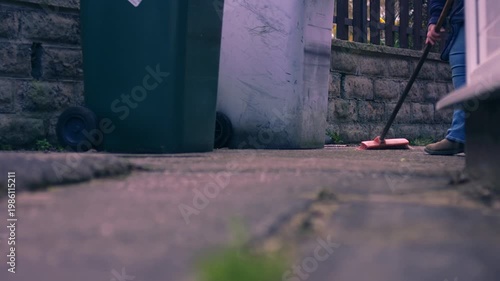 Sweeping yard with wooden broom 