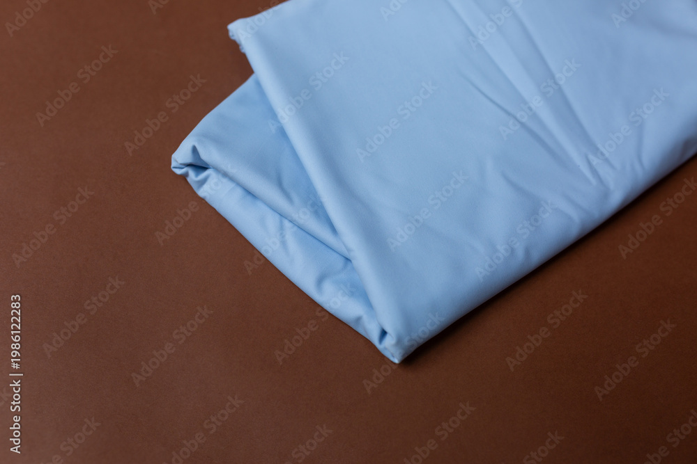 Fototapeta premium blue knitted fabric on a brown background