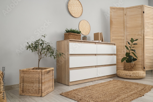 Tableau sur toile Interior of living room with wooden folding screen and commode