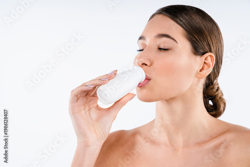 Quadro su tela Beautiful smiling woman drinking yogurt bottle isolated on white background, hea