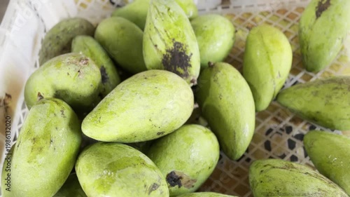 Fresh Green Mangoes in Traditional Market Basket