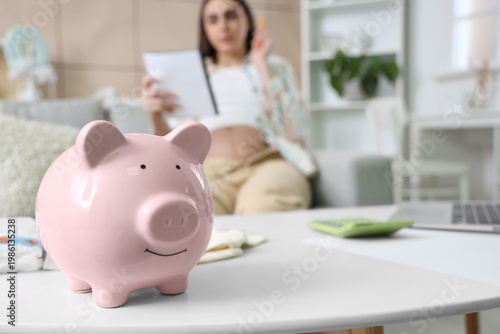 Piggy bank on table of preg...