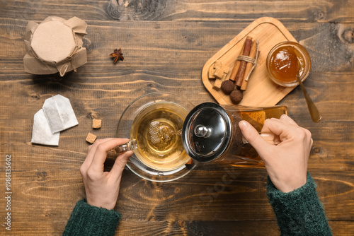 Woman pouring tasty hot tea...