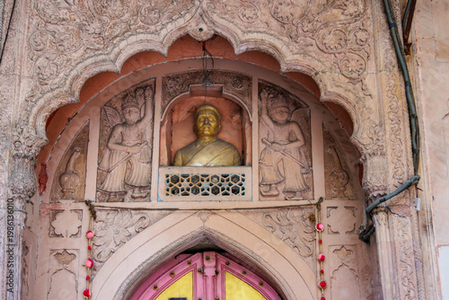 Ornate pink colored entrance of a building in Mughal style with a golden bust above a door - Old Delhi, Delhi, India, Asia