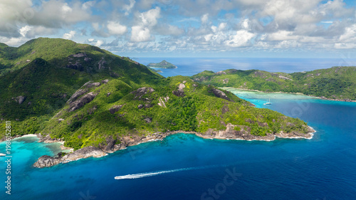 Coastline with lush green mountains descending into turquoise waters. Seychelles, Mahe.