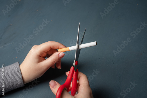 Conceptual image of quitting smoking by cutting a cigarette in half, symbolizing determination, breaking addiction, healthier lifestyle choices, and commitment to personal well-being.