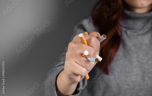 Conceptual image of quitting smoking by crushing a cigarette in a clenched fist, symbolizing strength, determination, breaking addiction, and commitment to a smoke-free lifestyle.