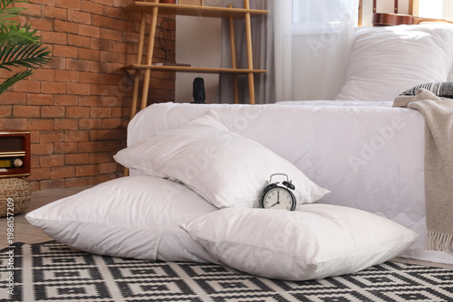 Alarm clock on white pillow...