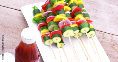 On cue camera is panning right and tightening crop, centering colorful skewers on platter for focus