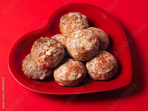 Bild auf Leinwand Traditional Russian style hard ginger cookies area on red heart shaped plate on red hot background