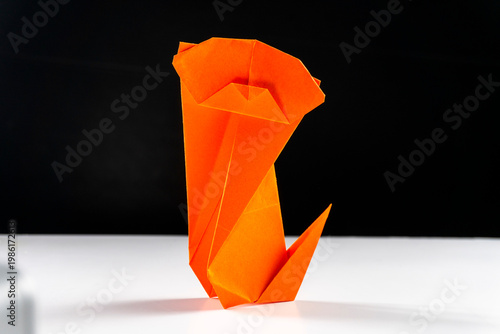 Bright colorful origami paper dogs  on a white surface. Concept of diversity, teamwork, and family represented by colorful paper figures.