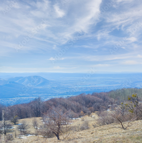 spring mountain ridge  in snow under a blue cloudy sky