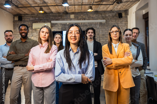 Fotografie Thai Businesswoman Leading Multiethnic Professional Team in V-Formation