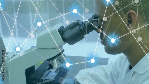 Lab tech leaning into microscope, bringing eye to eyepiece and initiating overlay, adjusting slide