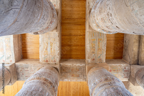 looking up at ancient stone columns with hieroglyphs and colorful carvings in the great hypostyle hall at the karnak temple complex in luxor upper egypt ruins