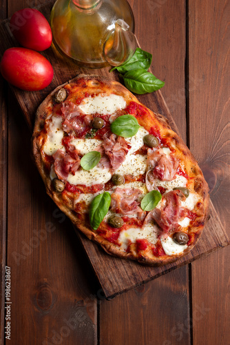 Pinsa romana con prosciutto cotto, mozzarella, sugo e olive 