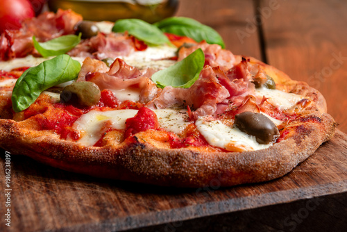 Pinsa romana con prosciutto cotto, mozzarella, sugo e olive 