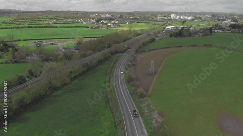 Gliding through serene countryside landscapes and suburban transition on a winding asphalt road, exploring new horizons and freedom.