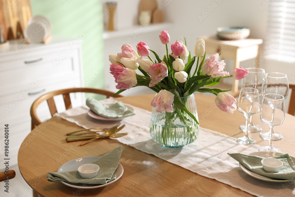 Fototapeta premium Stylish table setting with beautiful tulips, dishware and glasses in dining room, closeup