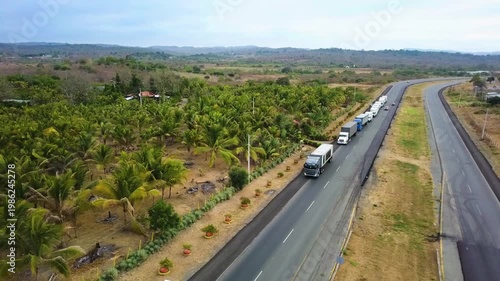 Aerial View of Truck Convoy on Highway Through Mountain Landscape