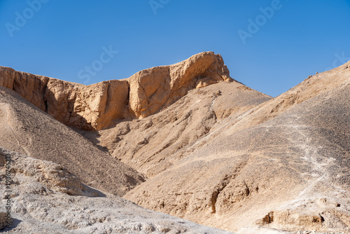 majestic view of rugged limestone cliffs and arid desert mountains in the valley of the kings historical site near luxor egypt under a clear blue sunny sky now