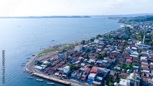 Tableau sur toile Clear aerial drone footage of Parepare coastal town in South Sulawesi, Indonesia, featuring dense urban housing along the blue sea under bright direct midday sunlight