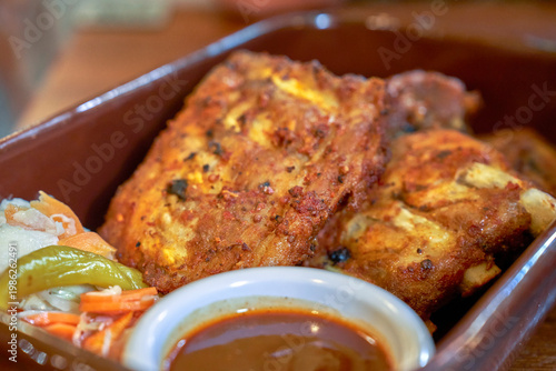 Pork ribs with barbecue sauce and pickles in the restaurant   