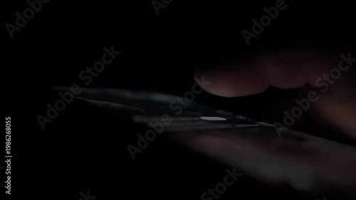 Man Scrolling Social Media on Smartphone at Night