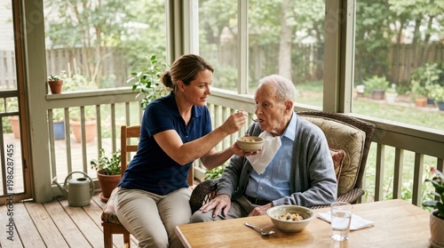 Young caregiver feeding elderly man on sunny porch with garden view