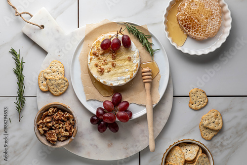 Top down view of brie with honey served with grapes and crackers.