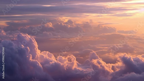 Soft pastel sunset above cottony clouds with pink and purple hues reflecting warm evening light and tranquil aerial perspective