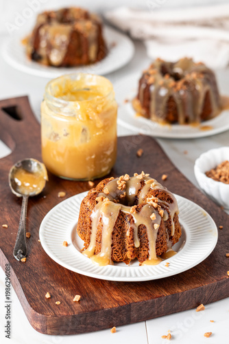 Servings of sticky toffee pudding with caramel sauce and toffee bits.