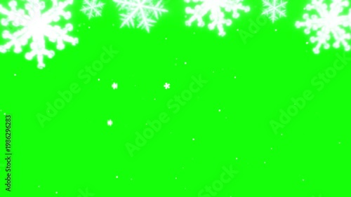 A video showcasing white snowflakes falling on a green screen background