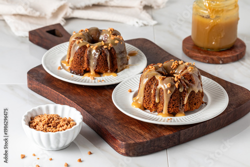 Servings of sweet sticky toffee pudding on a wooden board, ready for eating.