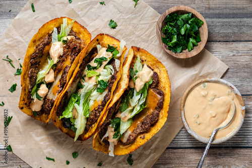 Top down view of smash burger tacos with fresh toppings, ready for eating.