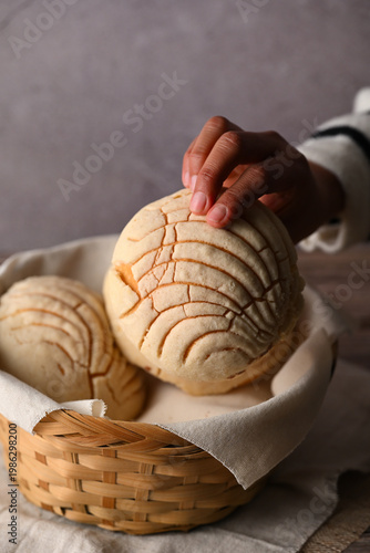 Obraz na plátně Close-up of a person grabbing a Mexican artisan bread from a basket