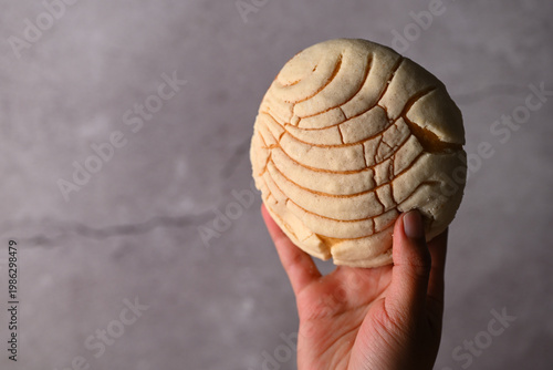 Bilde på lerret Hand holding a freshly baked pan dulce Mexicano, Concha bread