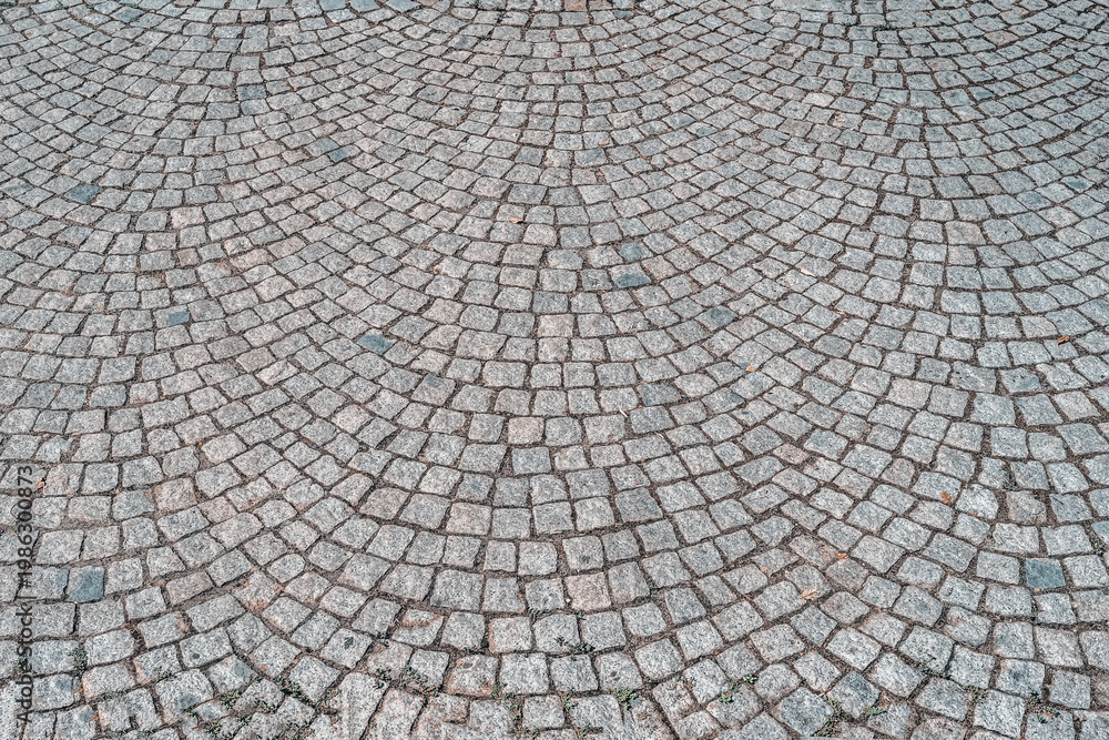 Fototapeta premium Cobblestone pavement pattern with curved layout, detailed cobblestone texture, masonry structure. Natural background featuring cobblestone texture for design, architecture, backdrop