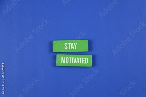Photos Stay Motivated Sign On dark blue Background With Green Blocks And Positive Messa