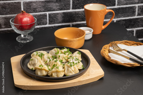 Delicious dumplings served on a black plate in a cozy dining setting